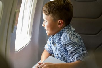 Boy excitedly staring out plane window
