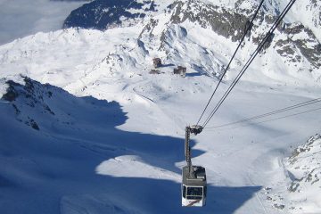 Gondola traveling up a snow-covered mountain