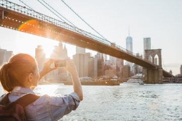 Woman taking a photo of the Brooklyn Bridge