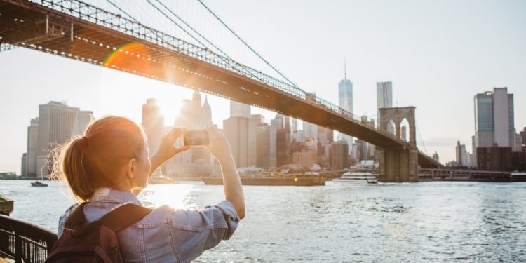 Woman taking a photo of the Brooklyn Bridge