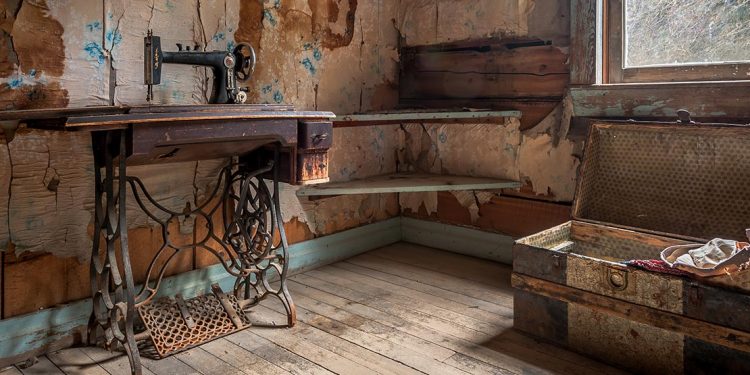 Sewing machine table and chest in dilapidated room