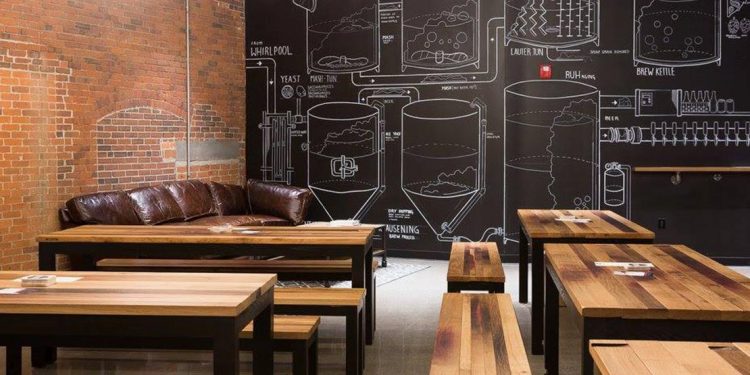Wooden tables with a couch and drawings of beer barrels on chalkboard