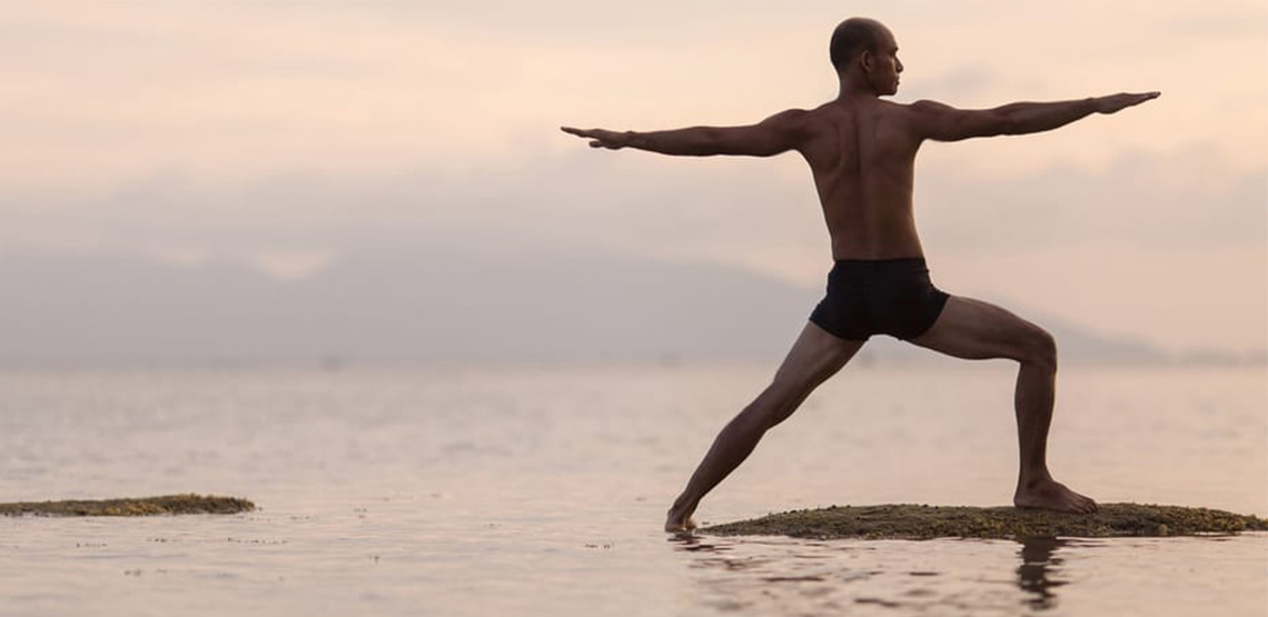 Man doing yoga on beach