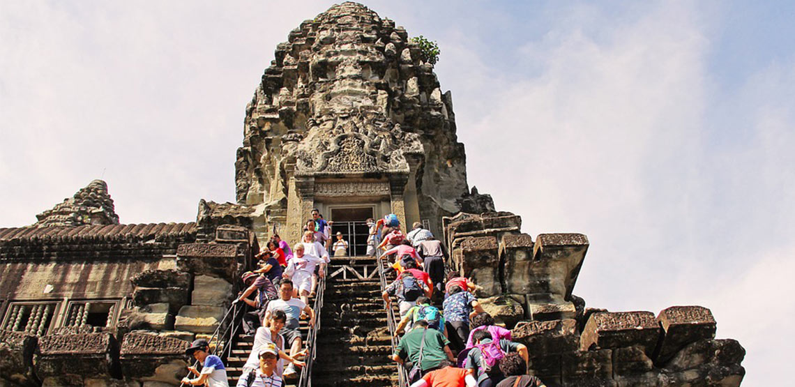 People walking up stairs to a temple
