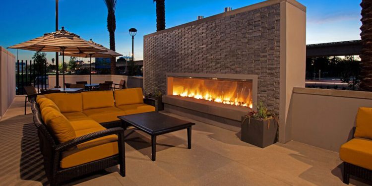 Outdoor fireplace by couch and table