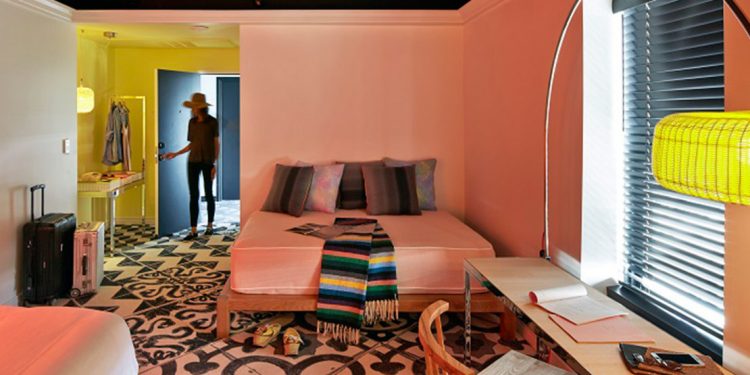 Colorful hotel room with someone walking in the door