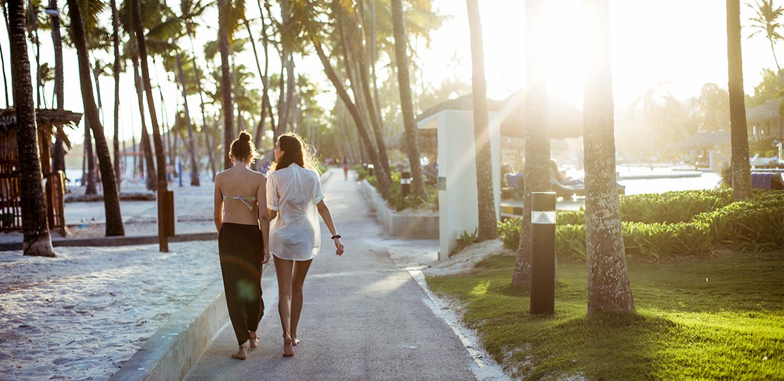 A pair of young women walk side by side on a Dominican Republic resort