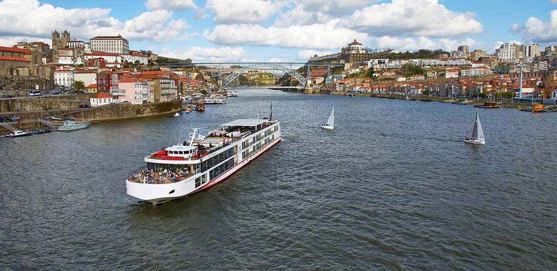 Cruise ship on a river with old buildings along the shore
