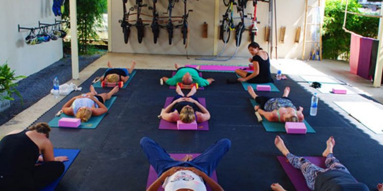 People lying on their backs on yoga mats