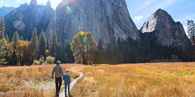 Man and child walking on single-track trail toward El Capitan in Yosemite