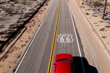 A red car driving on Route 66.