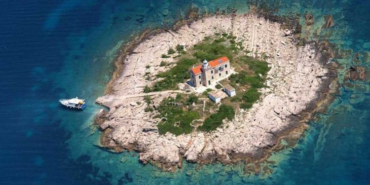 An overhead view of one of Croatia's private islands, with dark blue water and sandy beaches.