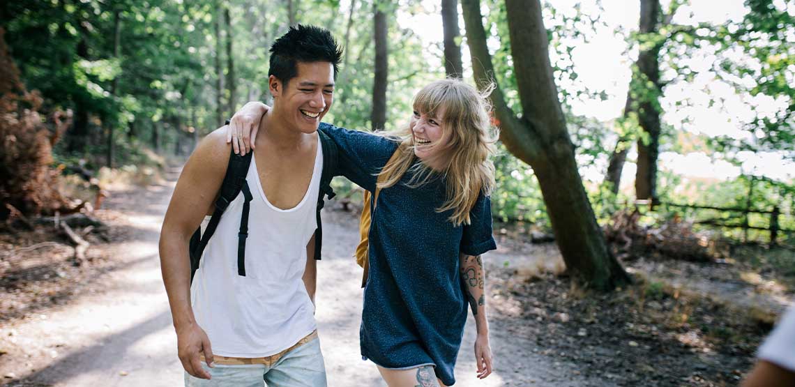 A couple walking outside in a forest.