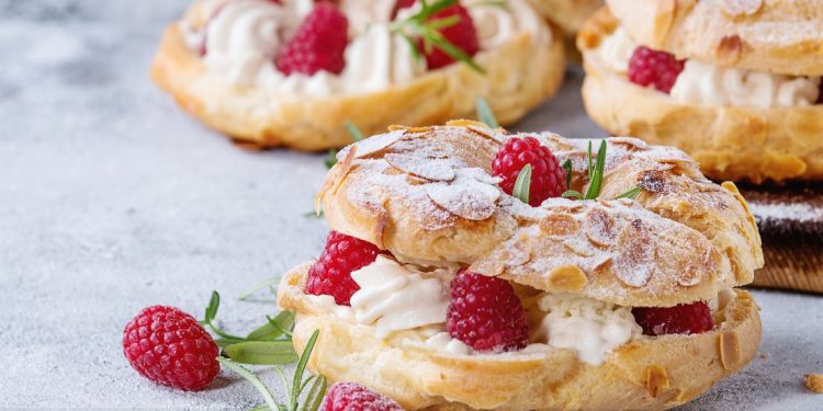 An almond croissant filled with cream and raspberries.